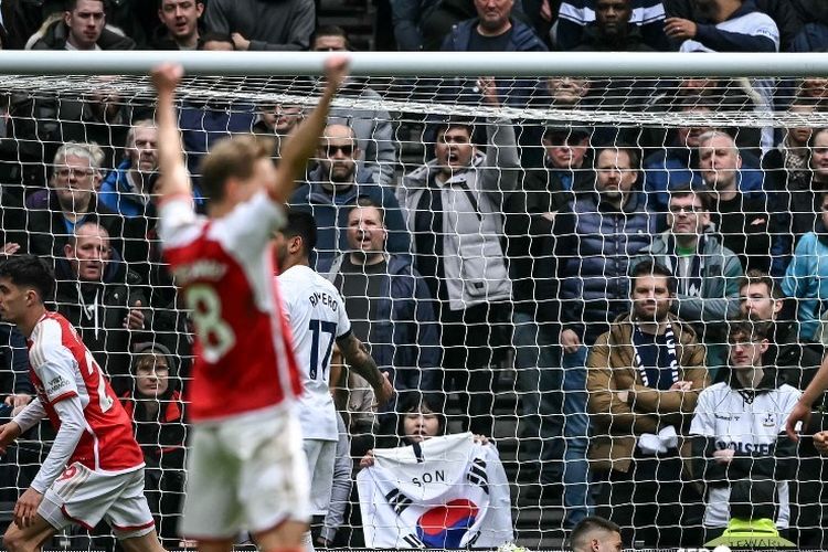Gelandang Arsenal Kai Havertz (kiri belakang) bereaksi setelah mencetak gol ketiga timnya pada pertandingan Liga Inggris antara Tottenham vs Arsenal di Stadion Tottenham Hotspur di London pada 28 April 2024. (Foto oleh Ben Stansall / AFP) / DIBATASI UNTUK PENGGUNAAN EDITORIAL.