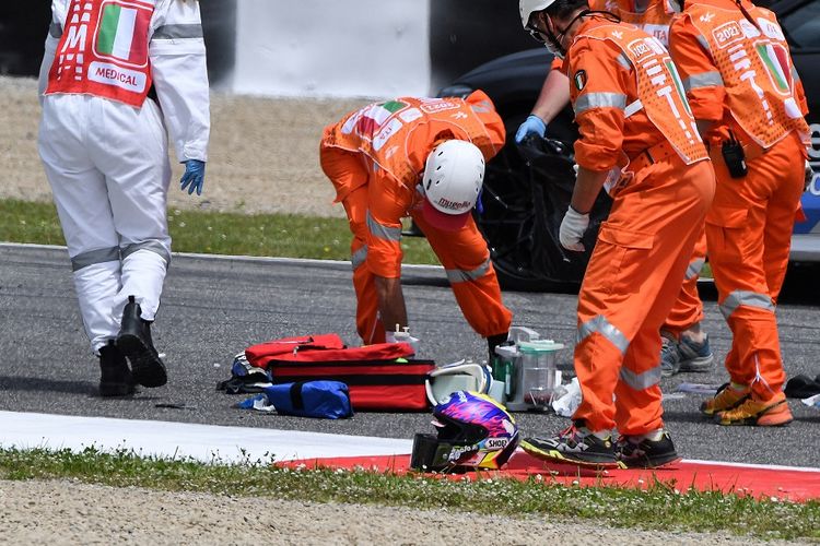 Petugas medis membersihkan lintasan saat mereka mengevakuasi pebalap Moto3 Jason Dupasquier dengan helikopter yang mengalami kecelakaan saat sesi kualifikasi MotoGP Italia di Mugello di pada 29 Mei 2021.