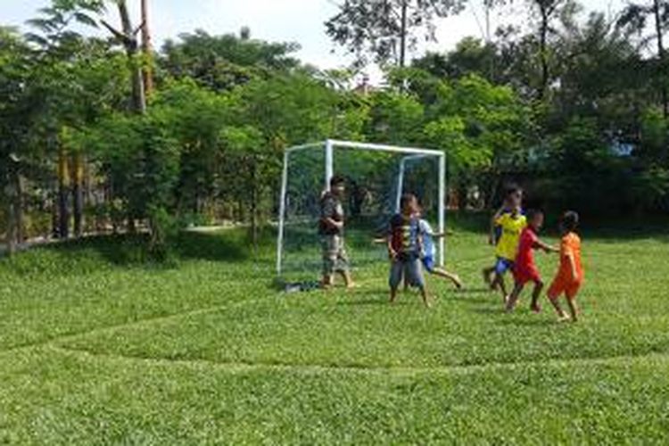 Anak-anak sedang bermain sepak bola di lapangan sepak bola mini TPA Rawa Kucing, Tangerang, Minggu (5/4/2015)