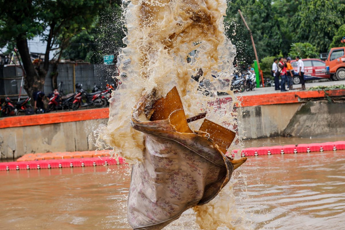 Petugas kebersihan DKI Jakarta mengangkut sampah yang terbawa arus menggunakan alat berat di Pintu Air Manggarai, Jakarta, Rabu (7/2/2018). Dinas Lingkungan Hidup dan Kebersihan DKI Jakarta telah mengangkut 1.596 ton sampah yang hanyut akibat air kiriman dari Bendungan Katulampa, Bogor pasca banjir yang melanda Jakarta. 