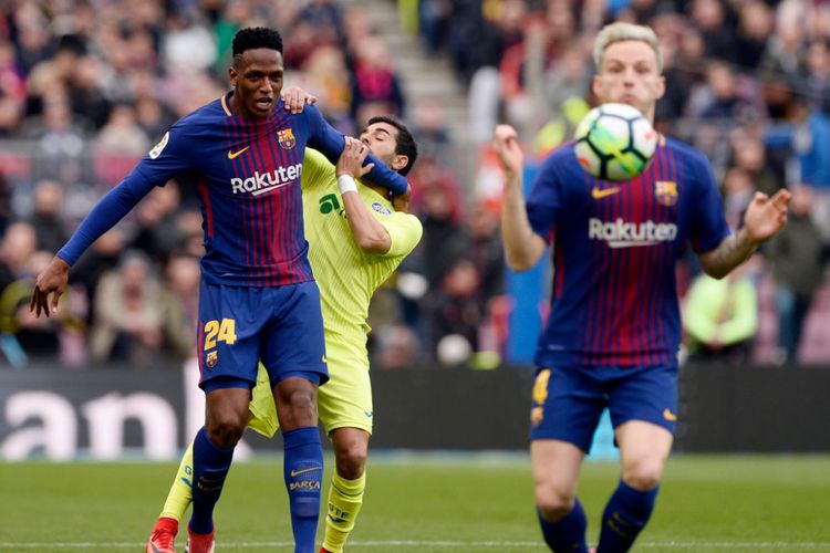Yerry Mina menahan laju Angel Rodriguez saat hendak mengejar bola yang berada dalam penguasaan Ivan Rakitic pada pertandingan La Liga antara Barcelona dan Getafe di Camp Nou, Minggu (11/2/2018).