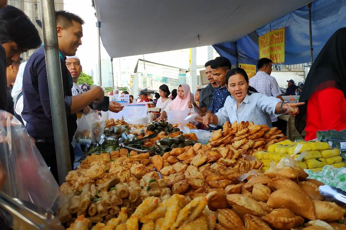 Seorang pedagang kue di Benhil sibuk melayani pembeli pada hari perdana Ramadhan, Senin (6/5/2019). Benhil dikenal sebagai pusat jajanan takjil di Ibukota yang selalu ramai pembeli.