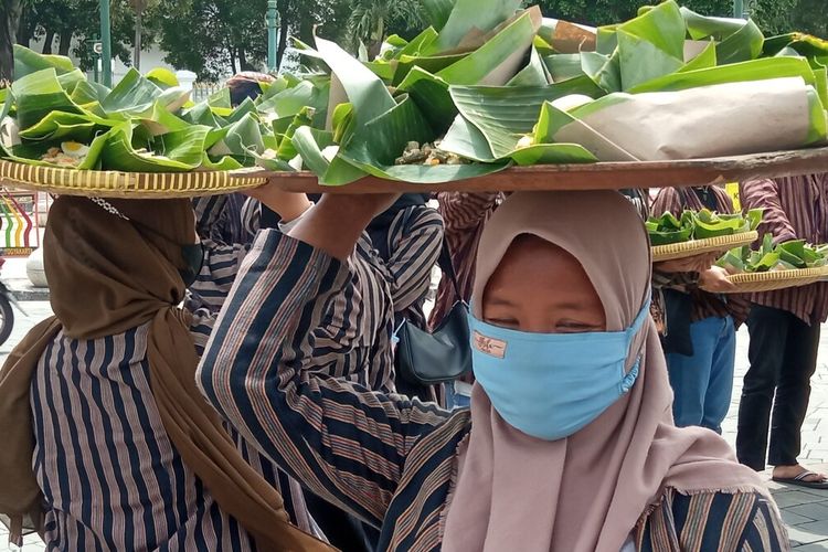 Forum Warga Yogyakarta saat melakukan aksi unjuk rasa dengan cara bagi-bagi nasi bancakan di kawasan titik nol Selasa (31/8/2021)