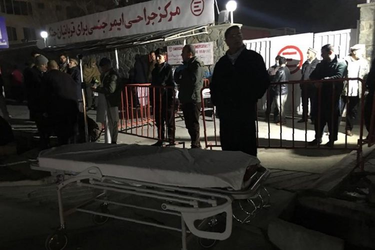 Kerabat dan staf medis Afghanistan menunggu korban di luar gerbang masuk rumah sakit setelah sebuah bom truk meledak di dekat kompleks asing, di Kabul, Afghanistan, Senin (14/1/2019). (AFP/WAKIL KOHSAR)
