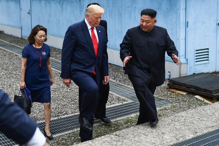 Presiden Amerika Serikat Donald Trump berjalan bersama Pemimpin Korea Utara Kim Jong Un di Zona Demiliterisasi pada Minggu (30/6/2019).