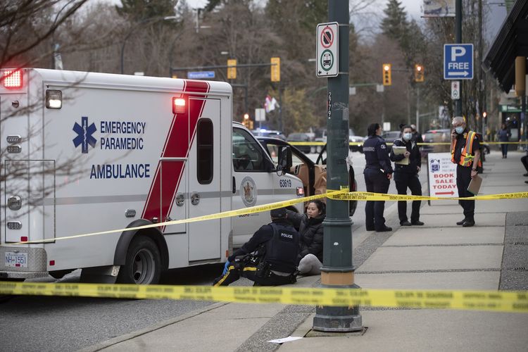 Polisi Kanada berbicara dengan seorang wanita di luar Lynn Valley Library, Vancouver utara, Kanada, pada Sabtu (27/3/2021). Polisi mengatakan, beberapa orang ditusuk di dalam dan luar perpustakaan.