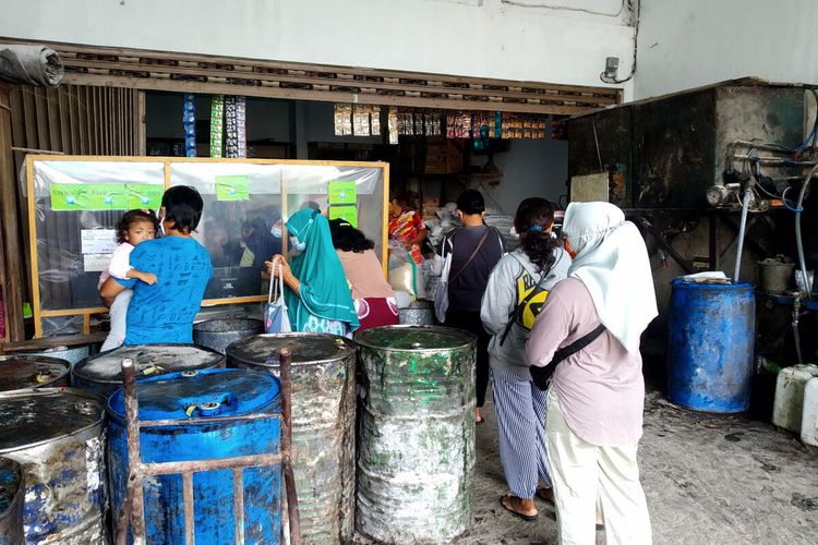 Warga mengantre minyak goreng curah yang dijual sesuai HET yang ditetapkan pemerintah di agen Toko Setia Kawan di Jalan Merdeka, Kota Blitar, Sabtu (5/2/2022)