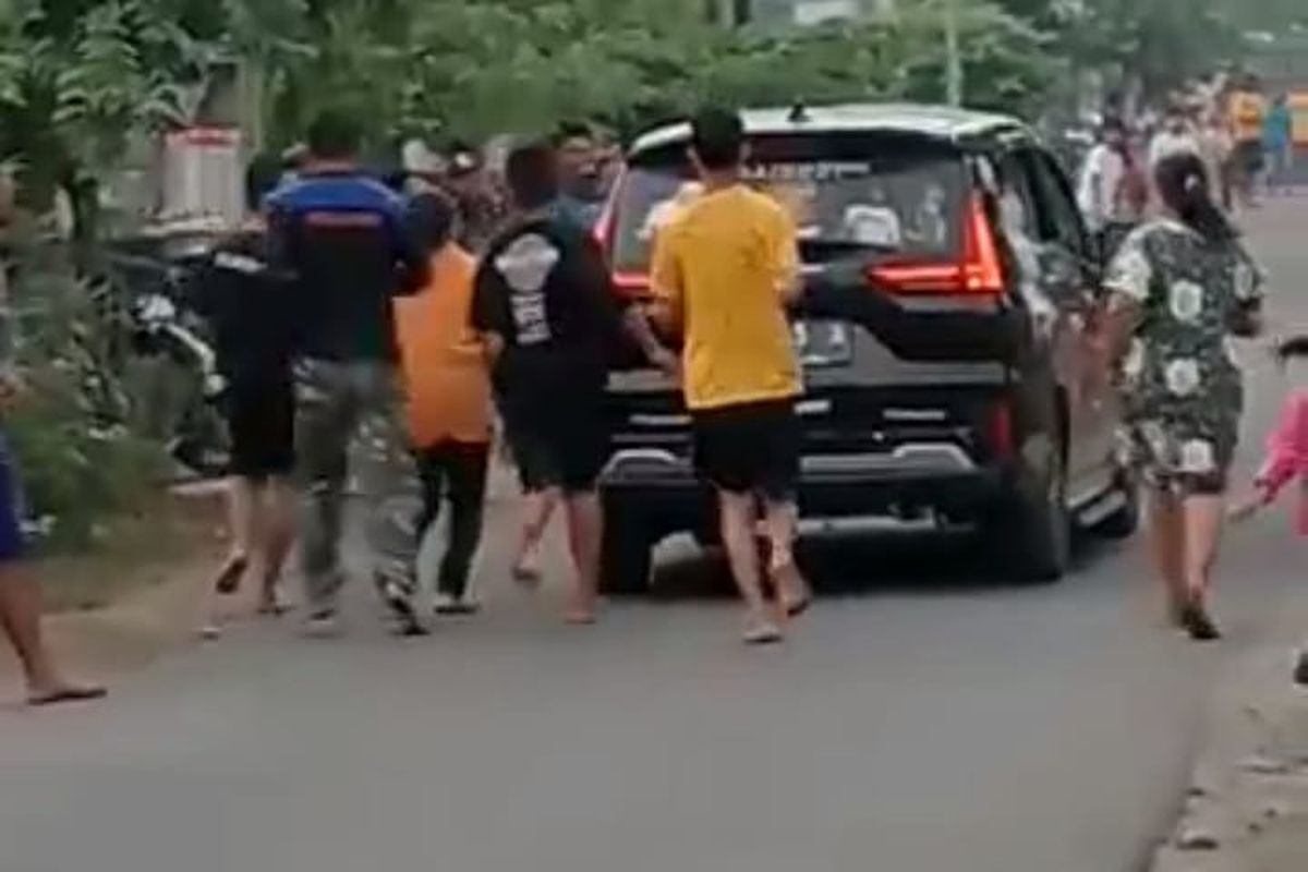 Tangkapan layar salah satu potongan video aksi penumpang mobil Xpander sebarkan uang di jalan di Dusun Watudakon, Desa Watudakon, Kecamatan Kesamben, Kabupaten Jombang, Jawa Timur.
