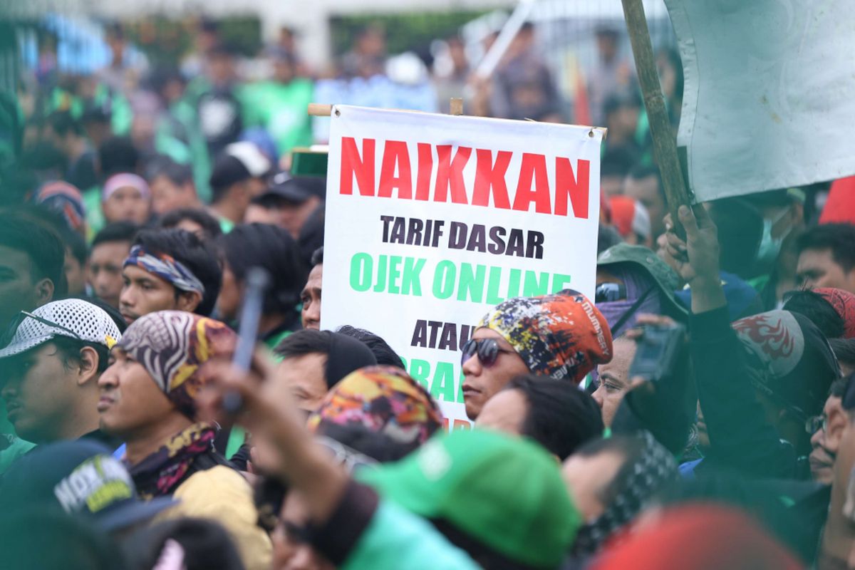 Sejumlah massa ojek online berunjuk rasa saat demo di depan Gedung DPR/MPR RI untuk berunjuk rasa menyampaikan aspirasinya, Senin (23/4/2018). Dalam demo ini para  pengemudi ojek online menuntut kenaikan tarif, Pengakuan legal, dan perlindungan hukum dan keadilan bagi ojek online.