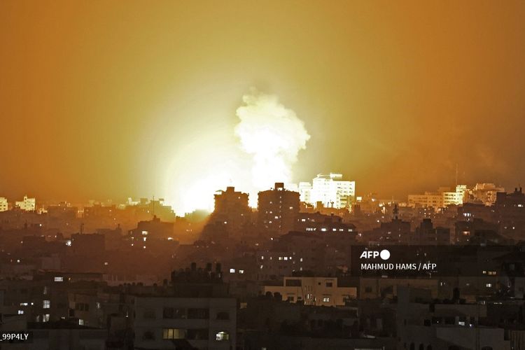 Bola api muncul dari serangan udara Israel di Jalur Gaza, yang dikendalikan milisi Hamas pada 10 Mei 2021. Israel menyerang Gaza setelah Hamas menembakkan roket yang menyasar Yerusalem buntut kerusuhan di Masjid Al-Aqsa.