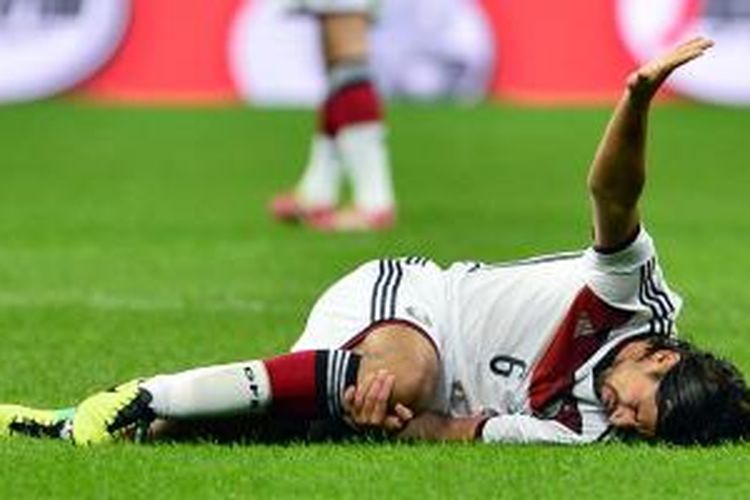 Gelandang Jerman, Sami Khedira, tampak kesakitan karena cedera lutut ketika negaranya melawan Italia dalam pertandingan uji coba di Milan, Jumat (15/11/2013).