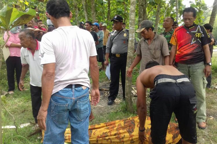 EVAKUASI  MAYAT --Warga dan aparat Polsek Bringan mengevakuasi mayat Sudir (30) yang ditemukan mengapung di waduk Pondok Turut, Desa Gandong, Kecamatan Bringin, Kabupaten Ngawi, Jawa Timur, Minggu ( 4/6/2017). 