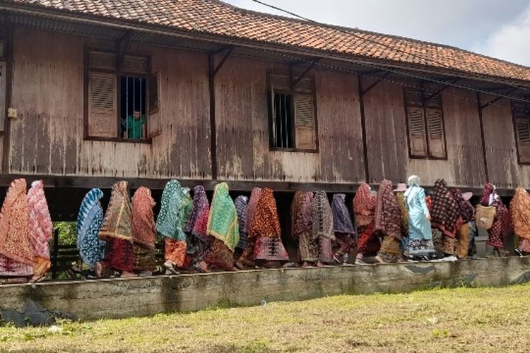 Para perempuan sedang mengenakan Tudung Lingkup sedang pawai dalam Festival Tudung Lingkup, Minggu (28/8/2022).