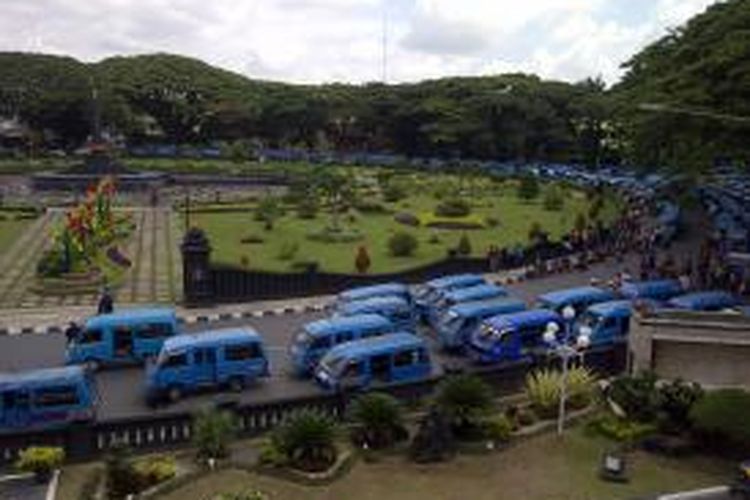 Ratusan sopir angkutan kota (angkot) saat gelar demo di bundaran tugu di depan balaikota Malang. Mereka menolak diperasikannya bus sekolah oleh pemerintah kota Malang.Kamis (22/1/2015).