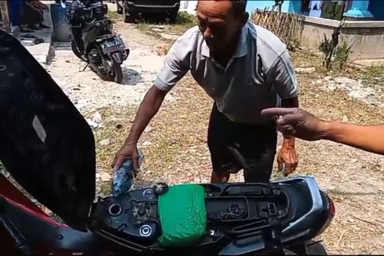 Seorang warga mengisi tangki motor menggunakan air sumur yang berubah warna biru atau tercemar minyak di Kampung Nagrog, Desa Pengasinan, Kecamatan Gunung Sindur, Kabupaten Bogor, Jawa Barat, Jumat (8/9/2023).