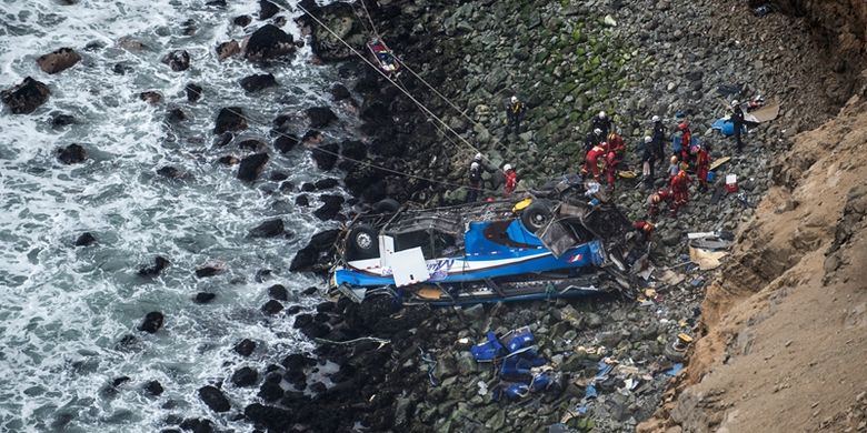 Tim penyelamat berupaya mengangkat korban bus jatuh dari ketinggian sekitar 100 meter di atas tebing, di jalan raya pesisir dekat Pasamayo, Peru, Rabu (3/1/2018). Bus mengalami tabrakan dengan truk pada Selasa (2/1/2018), sebelum terjun dan mendarat di pinggir pantai. (AFP/Ernesto Benavides)