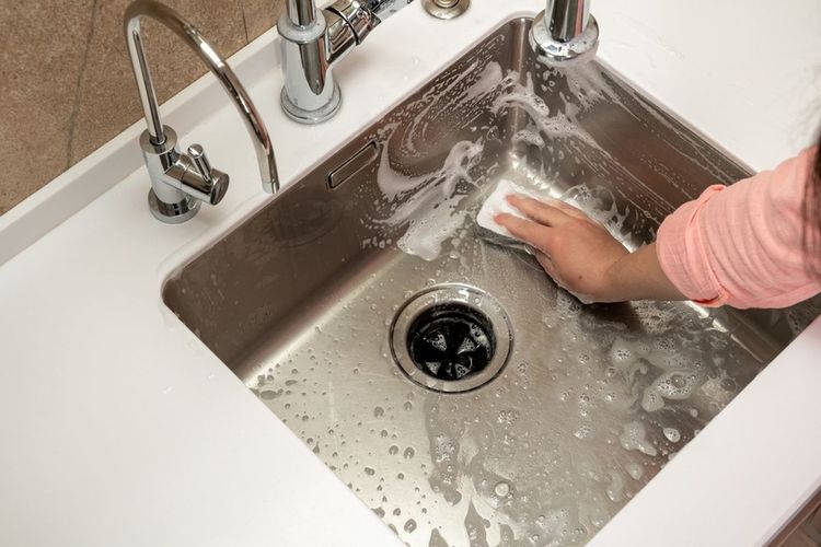 Ilustrasi membersihkan wastafel dapur. 