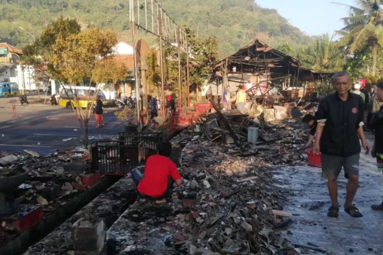 Warga tampak membersihkan sisa-sisa kebakaran dari bangunan RM Tahu Sumedang di Jalan Raya Bandung-Tasikmalaya, Minggu (7/08/2022) malam