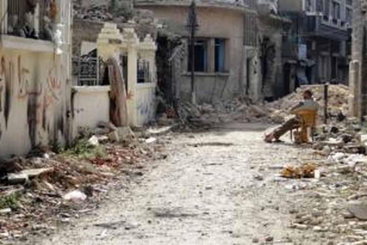 Suasana Kota Homs, Suriah akibat perang saudara berkepanjangan. Seorang warga tampak berada di antara reruntuhan bangunan yang rusak pada foto bertanggal 31 Januari 2014.