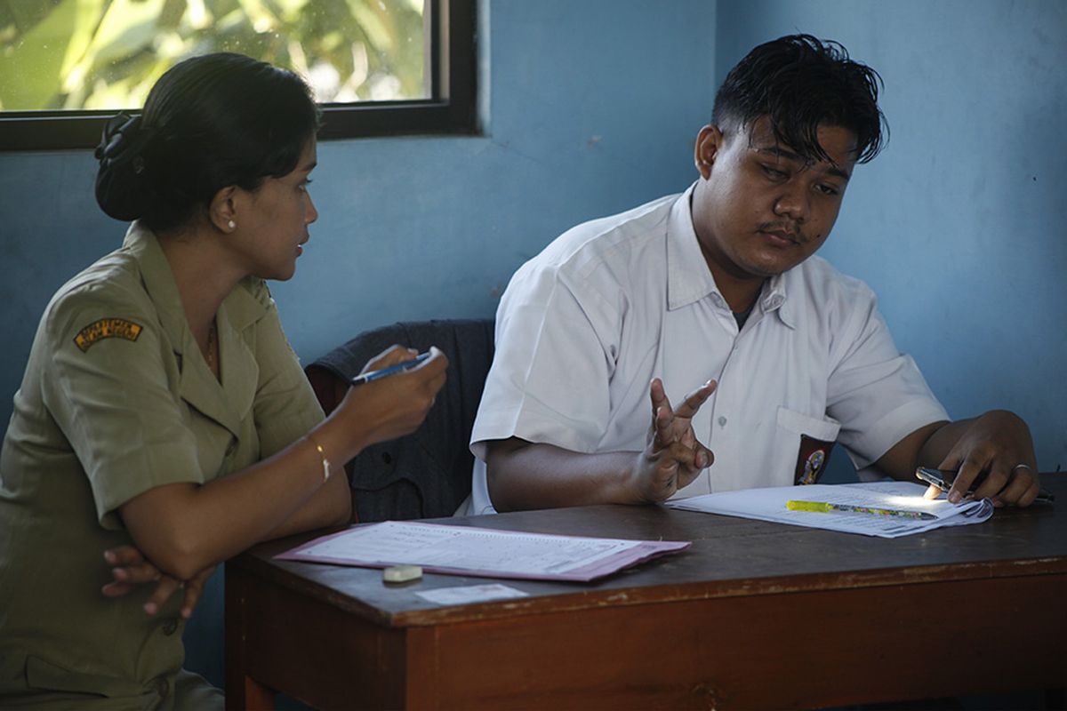 Seorang guru mendampingi siswa penyandang tuna netra dan penglihatan terbatas (low vision) SMALB YKAB Solo mengerjakan soal Ujian Nasional di Solo Jawa Tengah, Senin (1/4/2019). Pihak sekolah mempersiapkan guru pendamping, selain pengawas ujian, untuk membantu kebutuhan siswa dalam memperlancar pelaksanaan Ujian Nasional.