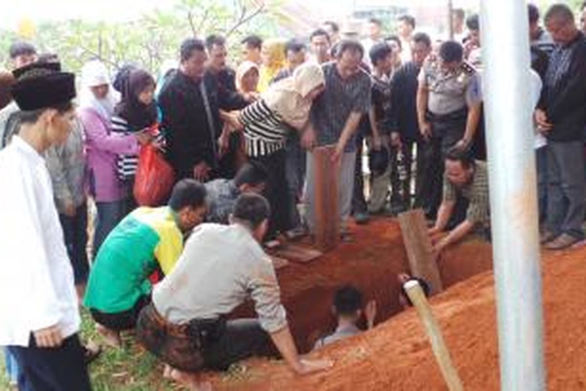 Suasana pemakaman almarhum Aiptu Dwiyatna, di tanah wakaf, Pamulang Barat, Tangerang, Rabu (7/8/2013). Suasana haru menyelimuti lokasi. Istri beserta tiga anak almarhum tampak kegilangan atas kepergian Dwiyatna secara mendadak.