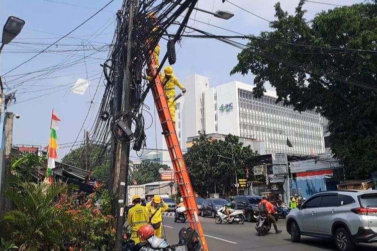 Petugas dari Sudin Binamarga Jakarta Pusat merapikan kabel fiber optik yang putus di Jalan KS Tubun, Slipi, Palmerah, Jakarta Barat, Kamis (10/8/2023). 