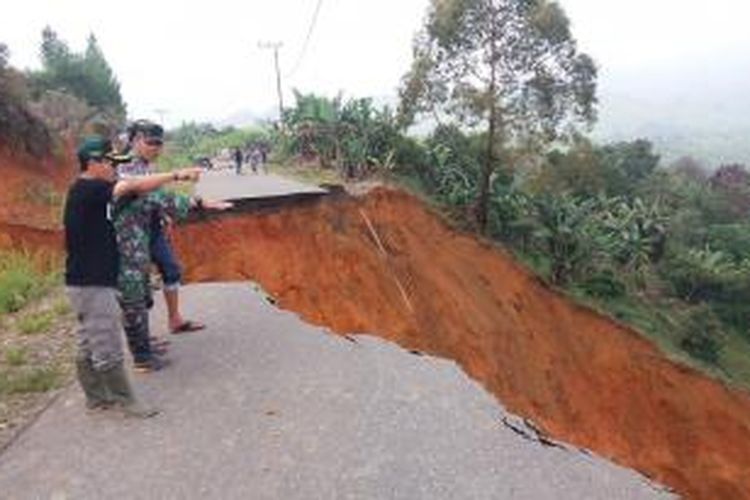 Camat Linge, Abdul Kasim bersama seorang anggota Babinsa Koramil Isaq, di lokasi amblasnya jalan provinsi, Isaq - Jagong Jeget., Jumat (23/10/2015).