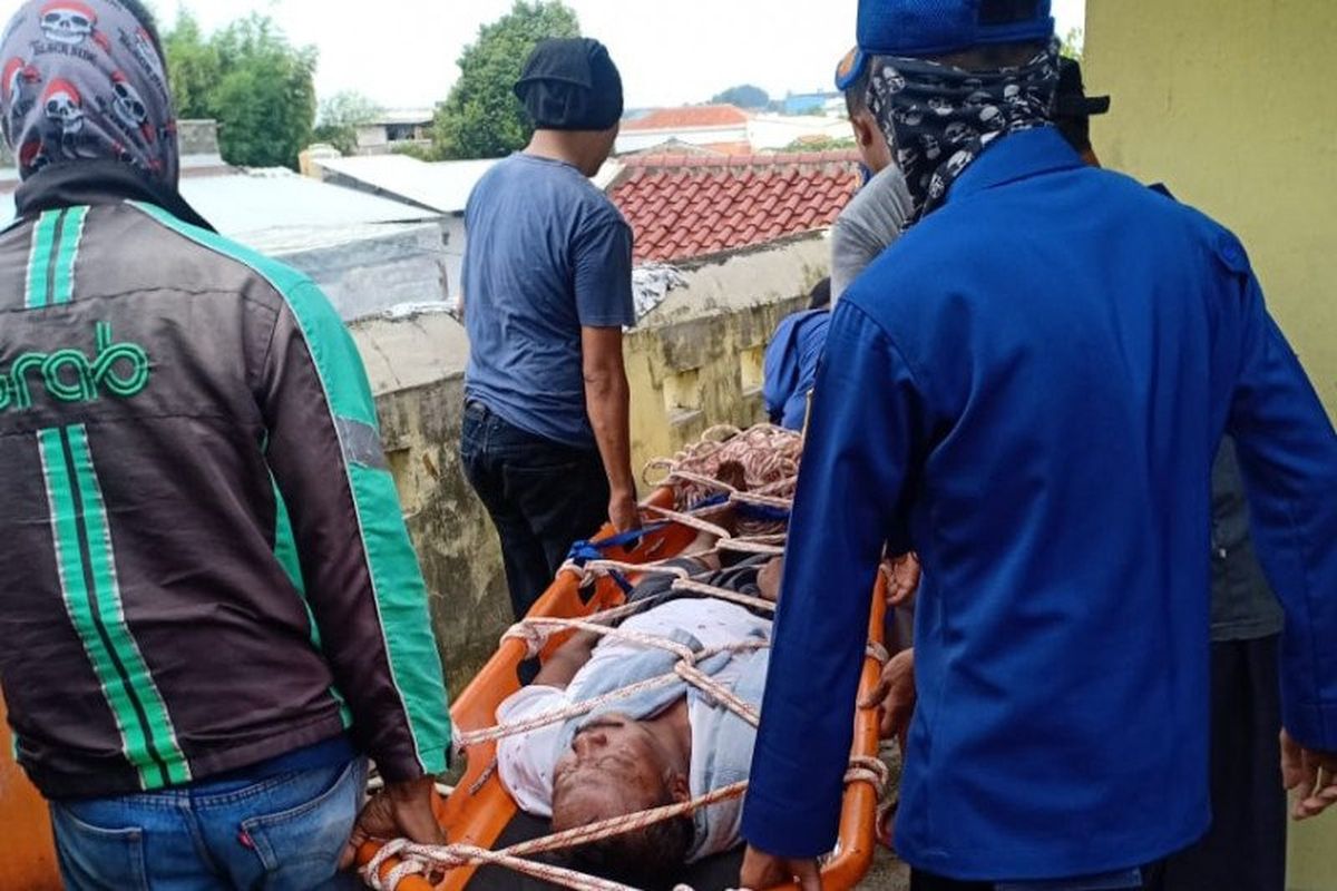 Petugas pemadam kebakaran Jakarta Timur bersama warga mengevakuasi seorang penderita stroke yang terjebak di lantai dua rumahnya Jalan Olahraga RT11 RW02 Batu Ampar, Kecamatan Kramat Jati, Kamis (28/5/2020).