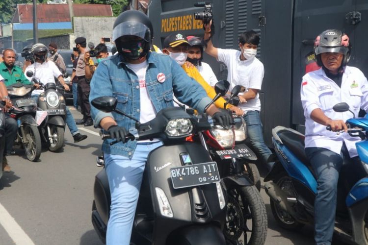 Muhammad Bobby Afif Nasution dan Aulia Rachman bersama rombongan partai pengusung konvoi menaiki Vespa menuju KPU Kota Medan untuk mendaftarkan diri sebagai bakal pasangan calon wali kota dan wakil wali kota Medan, Jumat (4/9/2020)