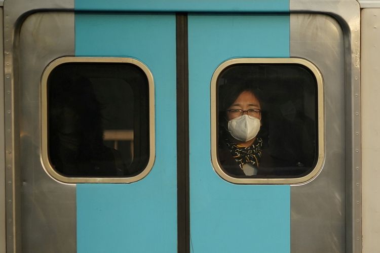 Seorang perempuan memakai masker pelindung mencegah penularan virus korona baru menaiki kereta bawah tanah di Seoul, Korea Selatan, Kamis (20/2/2020). ANTARA FOTO/REUTERS/Kim Hong-Ji/aww/cfo