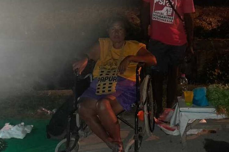 Maria Margaretha Solflanet (50) (pakai kursi roda) bersama suaminya, Fredi Fakum (62), saat berjualan sayur di pasar Youtefa, Kotaraja, Distrik Abepura, Kota Jayapura, Papua pada malam hari.