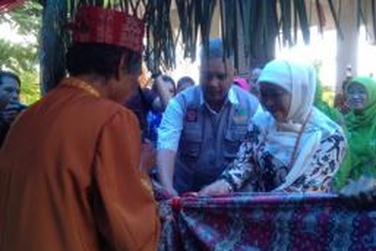Menteri Sosial Khofifah Indar Parawansa mengurai simpul timpung atau kain dalam upacara adat pantan timpung, di Bandar Udara Tjilik Riwut, Palangkaraya, Kalteng, Minggu (22/2).