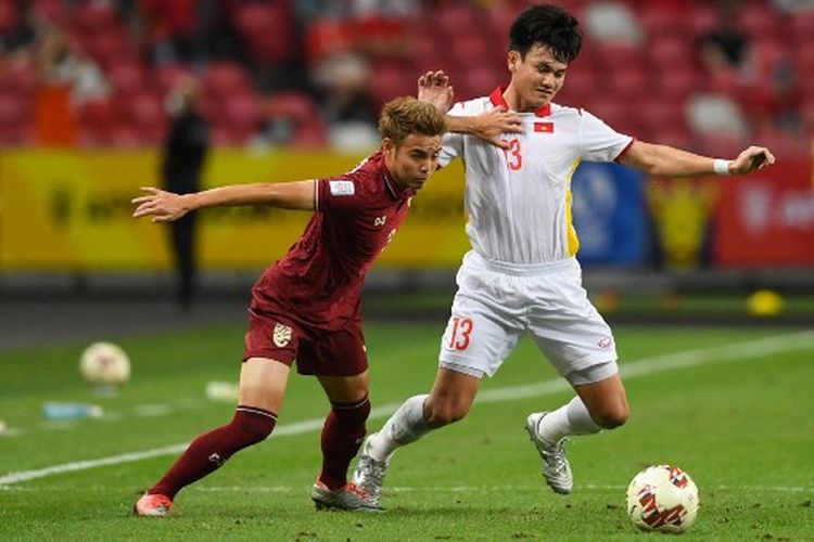 Theerathon Bunmathan (kiri) berduel dengan Ho Tan Tai (kanan) pada laga semifinal kedua Piala AFF 2020 yang mempertemukan Thailand vs Vietnam di National Stadium Singapore, Minggu (26/12/2021). Theerathon Bunmathan dipastikan absen membela Thailand pada leg pertama final Piala AFF 2020 kontra timnas Indonesia akibat akumulasi kartu.