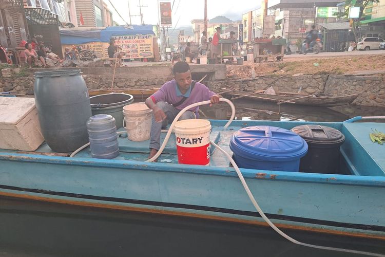 Michael Bobari, terlihat serius menyambungkan selang untuk menadah air di perahu fiber di pinggiran jembatan Sungai Hanyaan, Kelurahan Entrop, Distrik Jayapura Selatan, Kota Jayapura, Papua, Sabtu (22/10/2022).