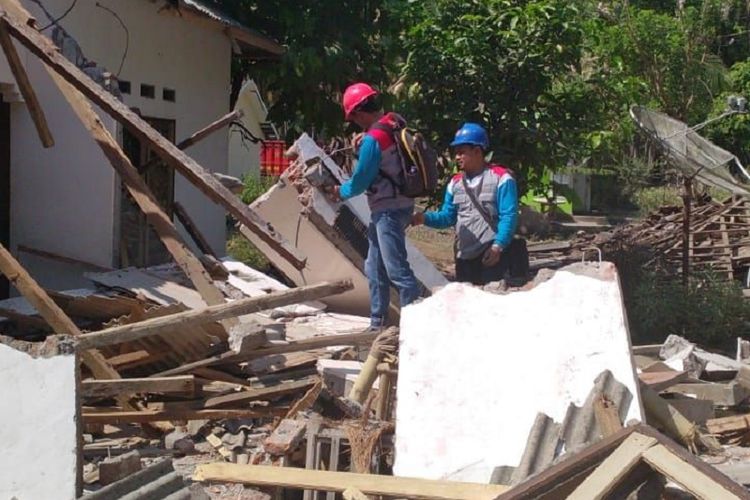 Petugas PLN memeriksa instalasi listrik di tengah puing-puing bangunan di Lombok, beberapa waktu lalu.
