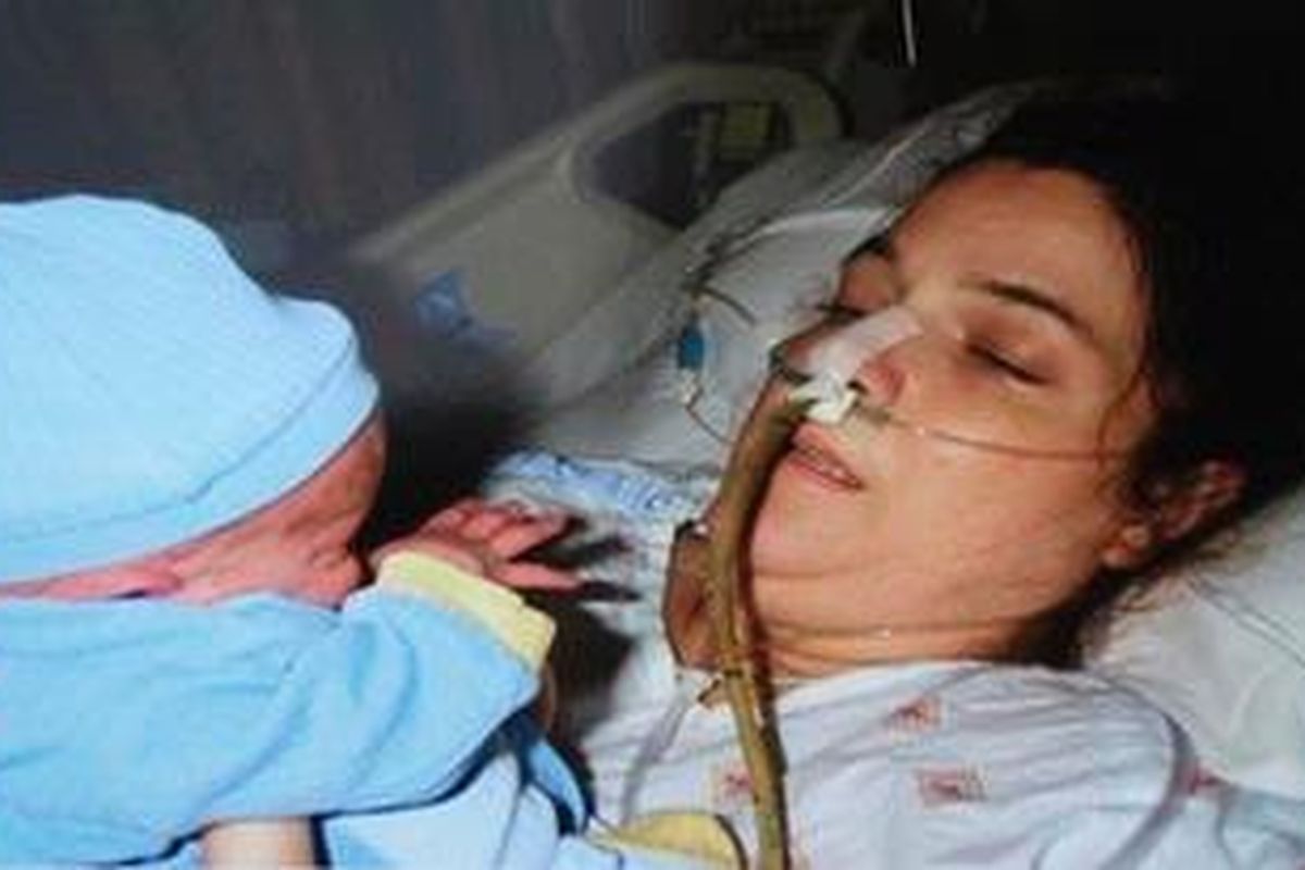 Foto yang diambil tahun 2005 ini memperlihatkan Christopher menjumpai ibunya, Sandy Wilson, di unit isolasi karena terinfeksi bakteri pemakan daging yang sangat langka.