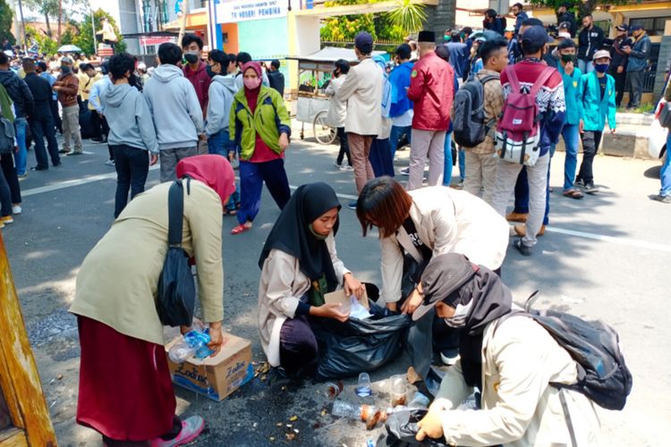 Mahasiswi Fakultas Peternakan Uniga dan aktivis lingkungan memunguti sampah di lokasi unjuk rasa tolak omnibus law di depan kantor DPRD Garut, Kamis (8/10/2020)