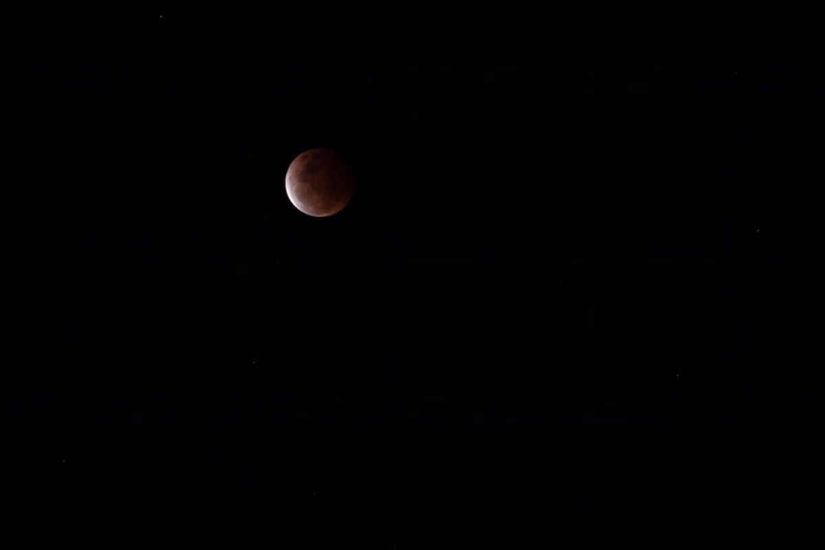 Penampakan gerhana bulan total atau Super Blood Moon fase akhir total atau U3 di wilayah pesisir Pantai Karangsong Indramayu Jawa Barat, Rabu (26/5/2021). Penampakan fase penumbra (P1) dan fase awal sebagian (U2) tidak terlihat di lokasi tersebut. 