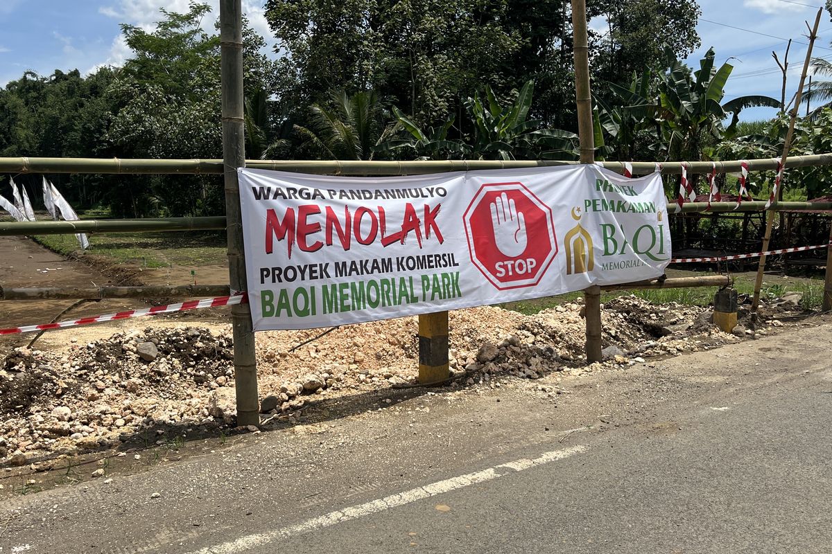 Spanduk penolakan warga atas rencana pembangunan proyek pemakaman komersial Baqi Memorial Park di Desa Pandanmulyo, Kecamatan Tajinan, Kabupaten Malang.