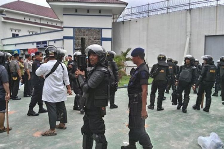 Personel Brimob melakukan pengamanan di gerbang sisi kanan Rumah Tahanan Sialang Bungkuk, Pekanbaru. Gerbang ini menjadi akses keluar tahanan yang kabur pada Jumat (5/5/2017).