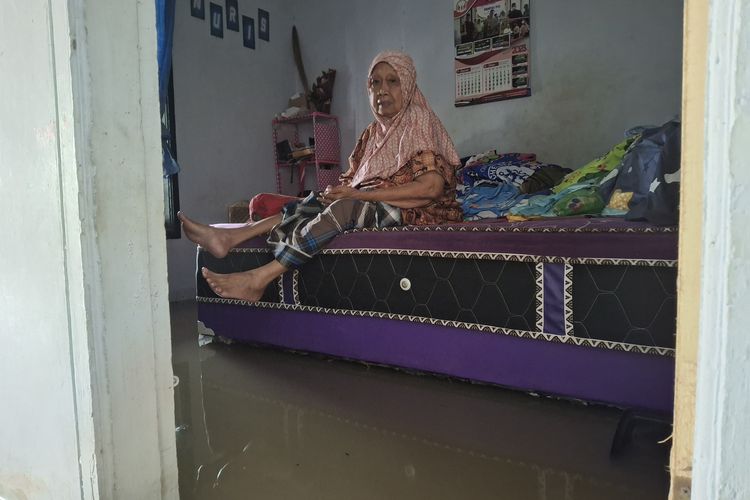 Nenek Masudah (75) terduduk di ranjang kamarnya saat banjir menerjang Desa Rojopolo, Kecamatan Jatiroto, Lumajang, Jumat (31/10/2025)
