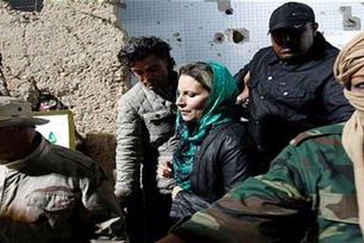 Aisha Khadafy, tengah, dikelilingi pengawalnya di Tripoli bulanlalu.