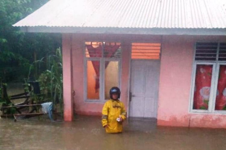 Warga melintasi genangan banjir di sebuah desa di Pulau Simeulue, Provinsi Aceh, Senin (10/1/2022) sore.
