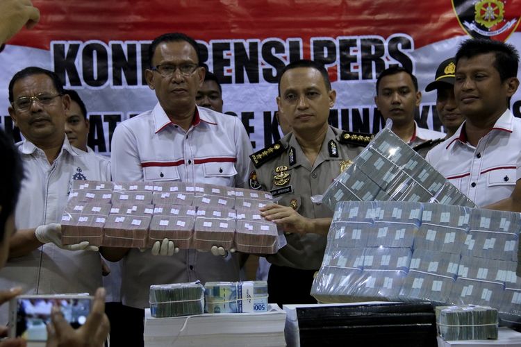 Kombes Pol T. Saladin Dirkrimsus  (kiri) dan Kombes Pol Ery Apriyono Kabid Humas Polda Aceh dalam komprensi pers di Polda Aceh, Rabu (09/10/2019) memperlihatkan bang bukti unag  Rp 2 Milyar yang diamankan dari tersangka kasus korupsi pada Kehutanan dan Perkebunan Kabupaten Bener Meriah,