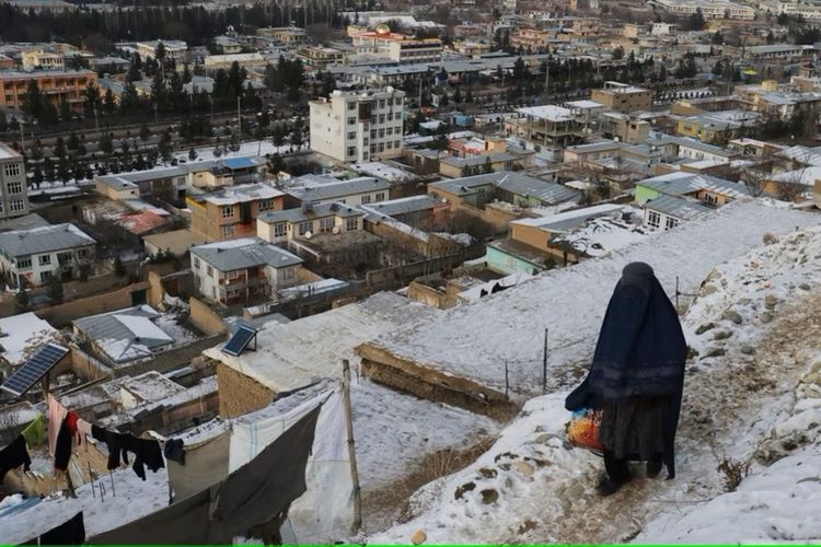 Seorang perempuan berjalan di jalan setapak saat musim dingin di Fayzabad, Provinsi Badakhshan pada 18 Januari 2023.