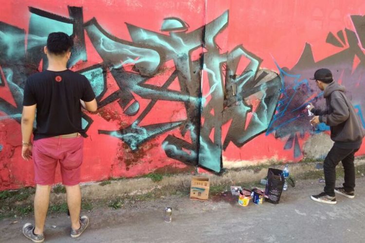 Seniman grafiti di Solo sedang melukis di salah satu tembok milik warga di Kampunh Kalitan, Solo, Senin (22/5/2017).