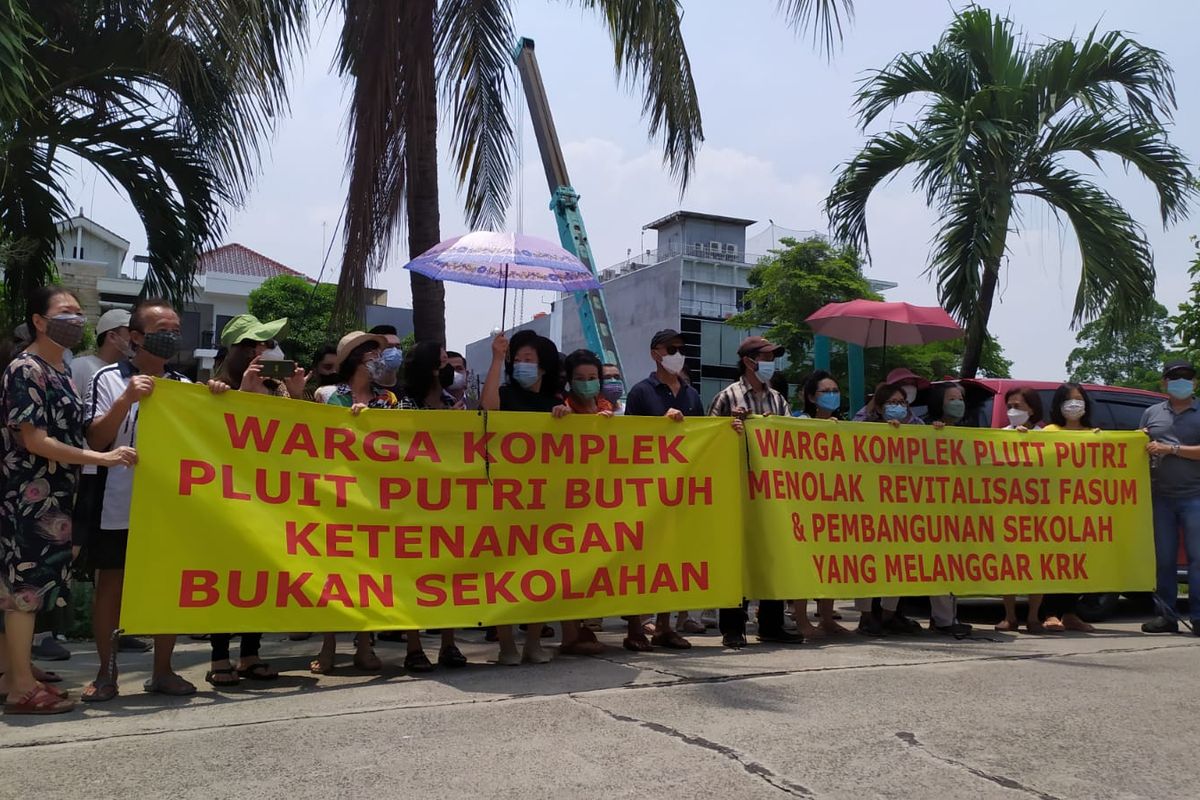 Warga Komplek Pluit Putri, Jakarta Utara, memprotes pengalihfungsian satu-aatunya lahan ruang terbuka hijau (RTH) di lingkungannya, menjadi bangunan sekolah swasta, Sabtu (30/10/2021) 