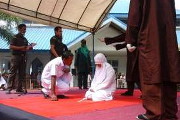 Petugas kesehatan menanyakan kondisi seorang terpidana cambuk, saat menjalani eksekusi cambuk di Banda Aceh, Senin (28/11/2016). Ia divonis sebanyak 100 kali cambukan. Terpidana ini mengaku dihadapan majelis hakim telah melakukan zina sebanyak dua kali bersama pacarnya.