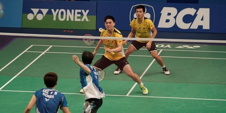 Pasangan ganda putra Malaysia, Tan Boon Heong/Tan Wee Kiong (kuning) bertahan menghadapi serangan ganda Korea, Lee Yong-dae/Yoo Yeon-seong, pada perempat final BCA Indonesia Open Superseries Premier 2014, Jumat (20/6/2014).