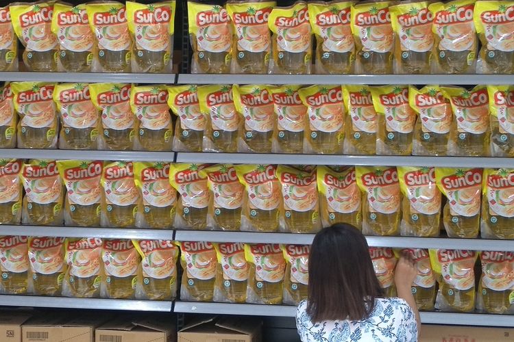 Seorang pekerja menyusun minyak goreng kemasan di sebuah supermarket yang kini memberlakukan harga baru, Rp 44.900 per 2 liter dari sebelumnya, Rp 28.000 per 2 liter.